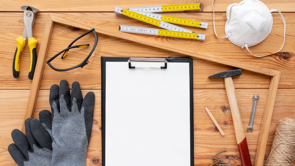 A wooden table displaying various tools and construction materials, showcasing a workspace ready for building projects.