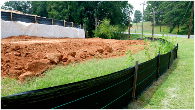 A construction area where mesh fencing has been installed for erosion control.