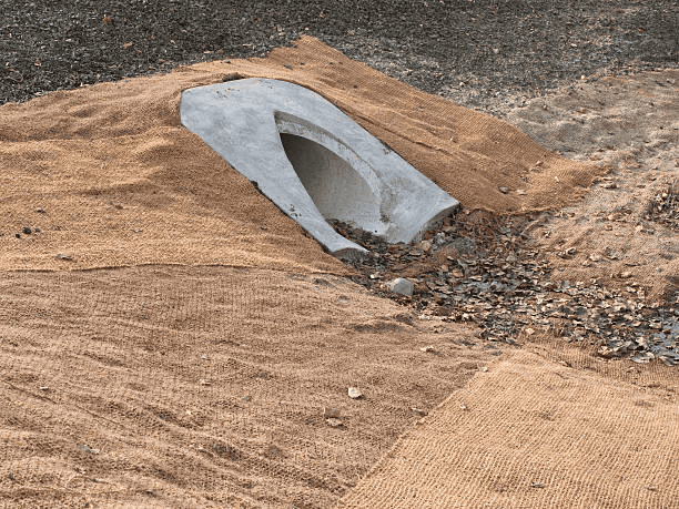 Jute netting being used as an alternative to an erosion control blanket on a slope.