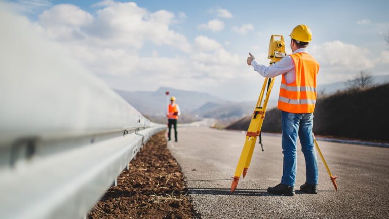 A new surveyor works with a trainer to mark survey positions.