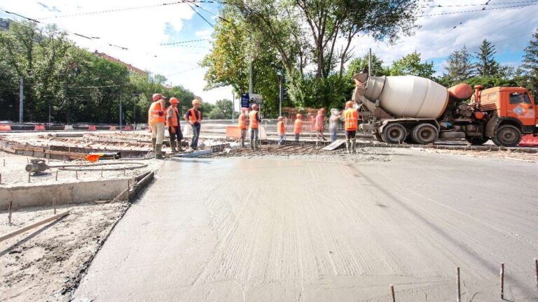 Construction crew members work on a site to lay out concrete.