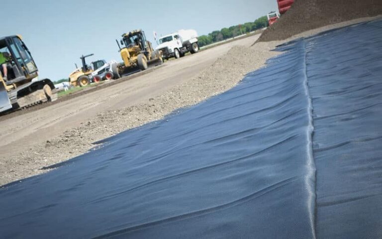 A black stabilization fabric laid out on a construction site.