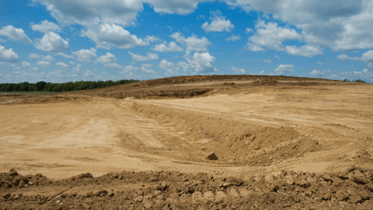 A dry, dusty construction site under a blue, summer sky.