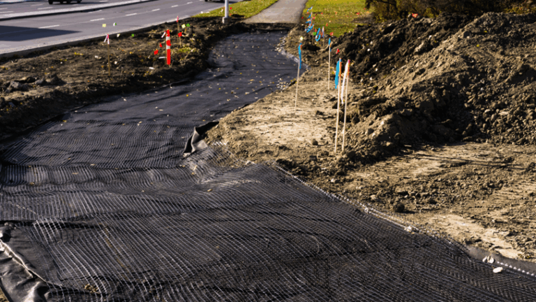 A geotextile fabric laid out where a sidewalk is being constructed.
