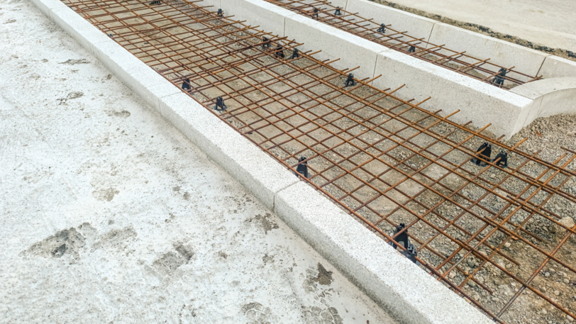 A shallow bed filled with latticed rebar waiting for cement to be poured.